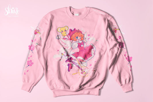Pink sweatshirt featuring Sakura from Cardcaptor Sakura in a dynamic jumping pose, perfect for anime fans and lovers of magical girl aesthetics.